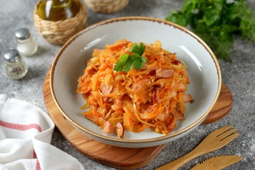 Braised cabbage with ham, onions and carrots. Traditional Russian food