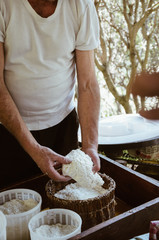Obraz na płótnie Canvas Man making cottage cheese outdoor