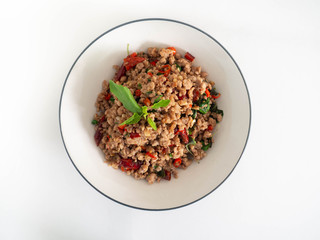 Stir fried basil with minced on a white plate,Thai food hot and spicy flavor. The ingredients are basil, garlic. Minced pork and Chili pepper,White background