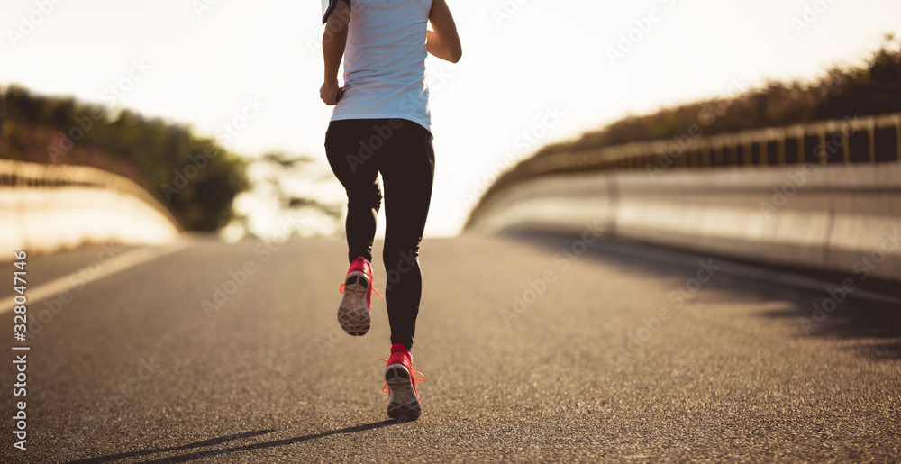 Wall mural fitness woman running on city road