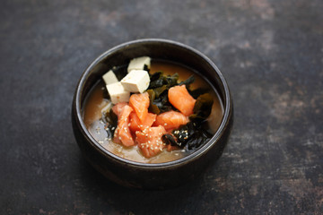 Ramen with seafood, salmon, crab sticks and algae.  Traditional Japanese cuisine. Eastern cuisine. Dish on a dark background