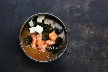 Fish broth with salmon, crab sticks and algae. Traditional Japanese cuisine. Eastern cuisine. Dish on a dark background