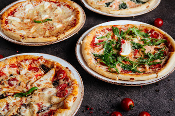 Traditional Italian pizza on a dark background top view copy space.