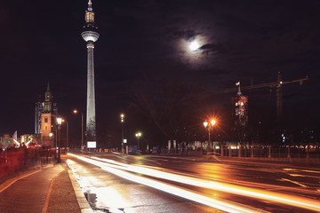 Naklejka na ściany i meble Street view of St. Mary Church (Marienkirche) and TV Tower (Fernsehturm) at night in Berlin, Germany.