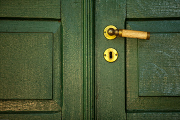 manaceta dourada em porta verde antiga