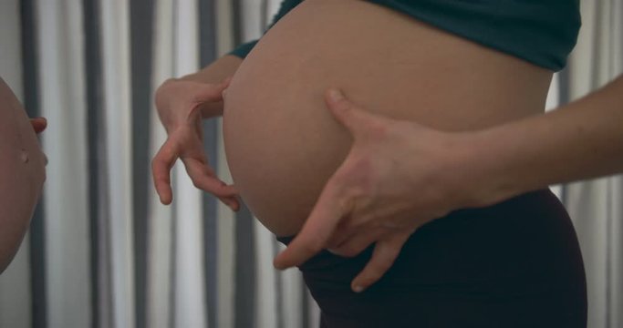 Two pregnant women comparing their bellies at 8 months