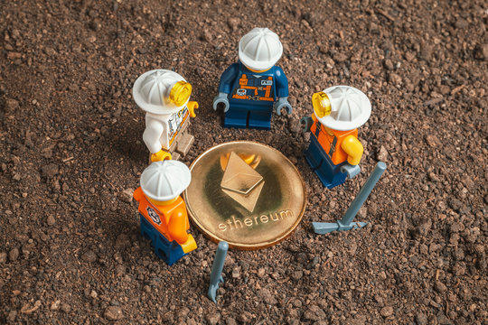 ANKARA, TURKEY. NOVEMBER 17, 2019. Group of Lego mini miner figurines dug ground and uncovered shiny ethereum. Cryptocurrency, blockchain and mining concept.