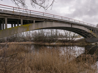 concrete arched bridge over a small and wild river
