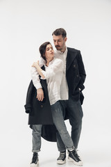 Near by. Trendy fashionable couple isolated on white studio background. Caucasian woman and man posing in basic minimal black stylish clothes. Concept of relations, fashion, beauty, love. Copyspace.