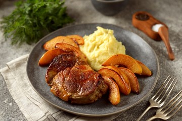 Roasted pork neck with quince, onion and mashed potatoes.