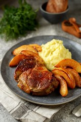 Roasted pork neck with quince, onion and mashed potatoes.