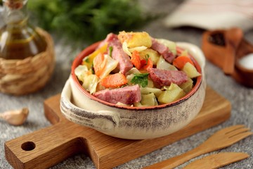 Stewed potatoes with ham, cabbage, onions, carrots and parsley. Homemade organic food.