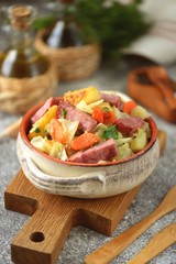 Stewed potatoes with ham, cabbage, onions, carrots and parsley. Homemade organic food.