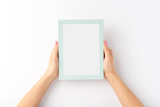 Woman’s hands holding empty photo frame on white background. Close up