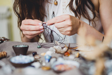 Woman making handmade gemstone jewellery, home workshop. Artisan woman creates jewellery. Art,...