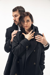 Memory creating. Trendy fashionable couple isolated on white studio background. Caucasian woman and man posing in basic minimal black stylish clothes. Concept of relations, fashion, beauty, love.
