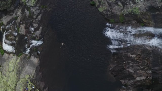 Man swimming drone aerial view in most beautiful waterfall Fisgas de Ermelo in Mondim de Basto, Portugal