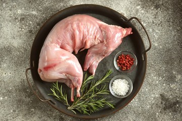 Fresh raw rabbit with rosemary, pink pepper and sea salt.