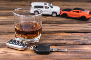 Glasses with alcohol car keys on the background of colliding cars. The concept of a drunken ride. Crash