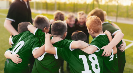 Coaching Youth Sports. Group Of Children In Soccer Team. School Football Coach’s Pregame Speech. Young Boys United In Football Team - obrazy, fototapety, plakaty