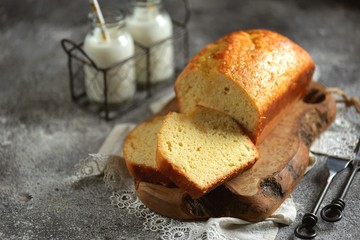 Tasty orange cake with milk on a wooden board. Homemade baking.