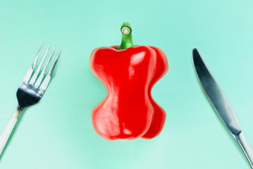 Fototapeta na wymiar Slender red paprika with Cutlery on a turquoise background. Flat lay. Copy space. The concept of diet, weight loss and healthy eating