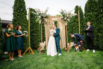 Fototapeta na wymiar beautiful boho style wedding ceremony. The bride in a beautiful dress and the groom in a classic suit