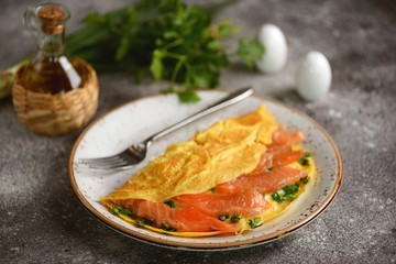 Omelet with green onions, parsley and salted salmon. Healthy food.