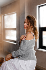 Fototapeta na wymiar Beautiful attractive sensual dreamy, attractive inspired girl in home clothes resting at home, enjoying privacy, self- care, self- love, creative workshop
