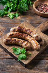 Fried sausages on a wooden Board on a wooden kitchen table. View top	