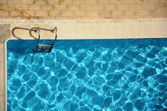 blue water in swimming pool and a ladder