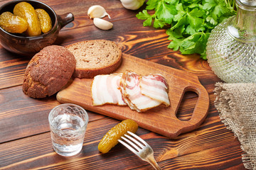 Vodka, pickles, lard, brown bread, parsley. Feast. Russian tradition. Close-up.