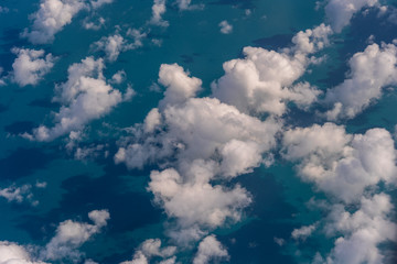 Flying above the earth and above the clouds in the territory of Singapore. Airplane window view. The plane flies in sky above the earth