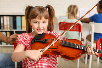 Little girl playing violin at music school