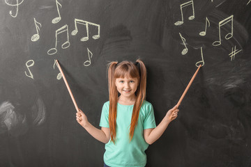 Little girl near chalkboard at music school - obrazy, fototapety, plakaty