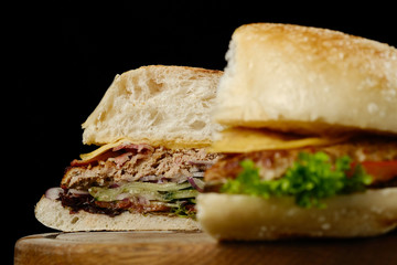 big fresh beef burger with cheese, tomatoes, onion. isolated on black background. closeup