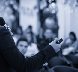 Business coach. Team leader teaches employees at a business meeting in a conference room. Speaker giving a talk at a corporate business seminar. Audience in hall with presenter in lecture photo.