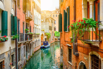Narrow canal with boat in Venice, Italy. Architecture and landmark of Venice. Cozy cityscape of Venice.