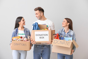 Volunteers with donations for orphans on grey background