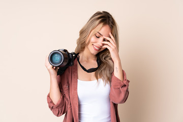 Young photographer girl over isolated background laughing