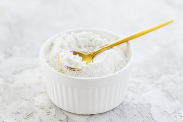 Gluten free flour in a white bowl on a gray table. Gluten free, healthy diet concept.