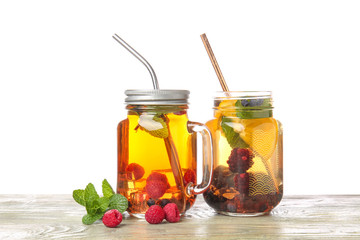 Mason jars of cold cocktails on table against white background