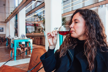 JEREZ DE LA FRONTERA SPAIN. DECEMBER 2, 2018: Woman drinking a glass of sherry wine in Tapería...