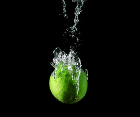 Falling of lime into water against dark background