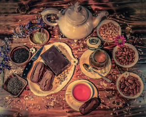 Tea table with vintage mother-of-pearl tea pot, cups and  saucers, flowers, pecans, cashews,...