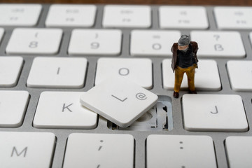 Old pensioner is looking at a broken computer keyboard
