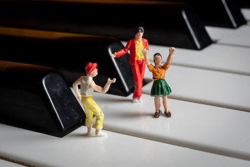 Miniature People having a party on a piano