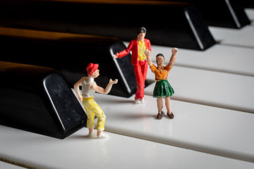 Miniature People having a party on a piano