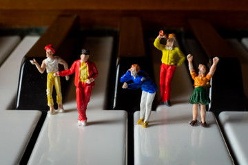 Miniature People having a party on a piano