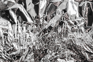 Texture of used crumpled aluminium food foil background. Shiny aluminum foil wrap without chocolate...